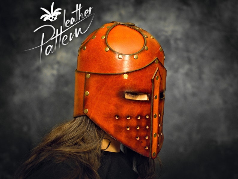 May include: A tan leather helmet featuring a central vertical ridge, a horizontal eye slit, and a series of small circular ventilation holes. The helmet is constructed with multiple panels joined by brass-colored metal rivets. Text reads Pattern Leather.