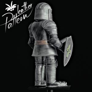 Puede incluir: Una detallada armadura de caballero de cuero gris con costuras blancas, un casco y un escudo con un dise&ntilde;o de cruz verde. La armadura se muestra sobre un fondo negro. El texto "leather Pattern" est&aacute; en la esquina superior izquierda.