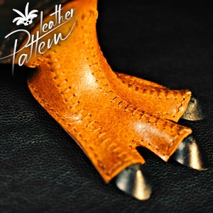 K&ouml;nnte beinhalten: Nahaufnahme einer braunen Lederkralle mit N&auml;hten und schwarzen Metallverzierungen. Die Kralle liegt auf einem schwarzen Hintergrund. "Leather Pattern" ist in orangefarbener Schrift oben links geschrieben.
