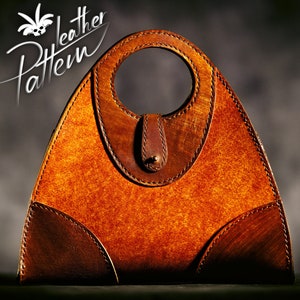 Peut inclure: Un sac à main en cuir brun de forme triangulaire avec une anse circulaire. Le sac a une fermeture à rabat avec une boucle décorative.