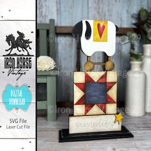Puede incluir: Una figura de oveja de madera con cuerpo blanco y negro, un cuadrado amarillo con un corazón rojo y ruedas de madera. La figura se asienta sobre un bloque con un patrón de estrella y la palabra "simplify". La imagen también incluye el texto "Iron Horse Vintage" y "Digital Download".