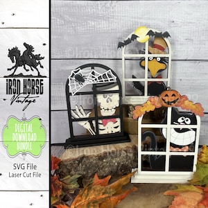 Puede incluir: Conjunto de decoraciones de Halloween cortadas con láser en forma de ventanas. Una presenta un esqueleto, otra un cuervo y la tercera un gato negro. Las decoraciones son en blanco y negro con detalles en naranja y amarillo. La imagen incluye el texto "Iron Horse Vintage" y "Digital Download Bundle".