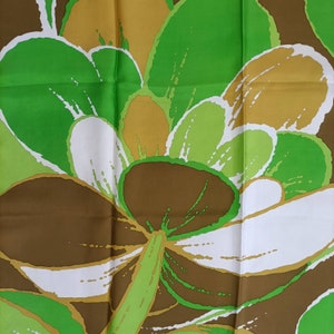 Op de afbeelding: Een bruine, groene en witte stof met een bloemenprint en een grote bloem in het midden. De stof heeft een zijdeachtige textuur en is perfect voor knutselprojecten.