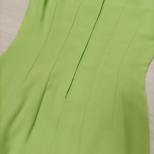 May include: A lime green dress with a back zipper closure. The dress has a fitted bodice and a flowing skirt.