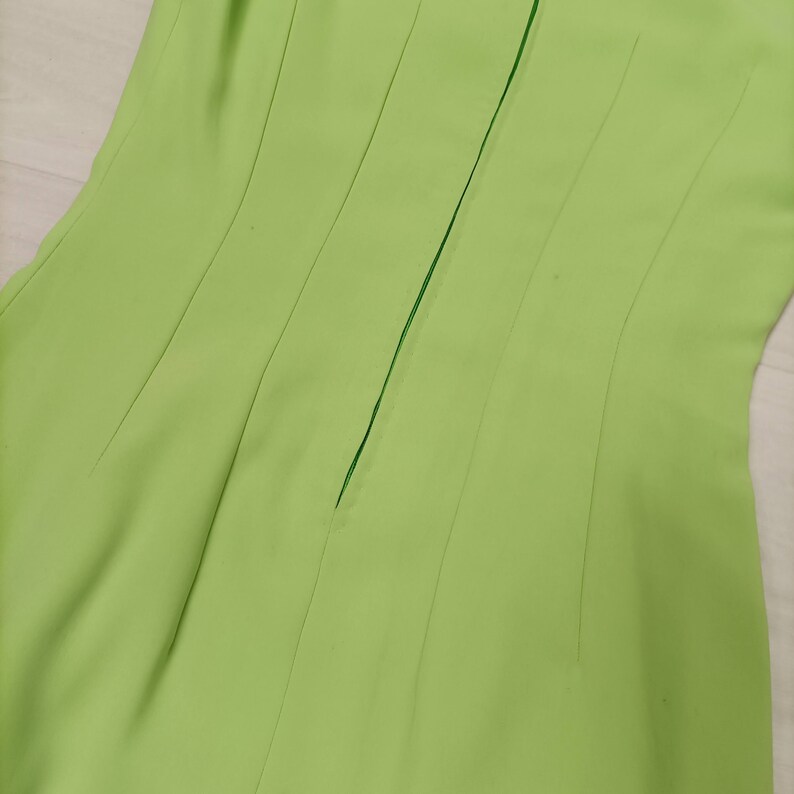 May include: A lime green dress with a back zipper closure. The dress has a fitted bodice and a flowing skirt.
