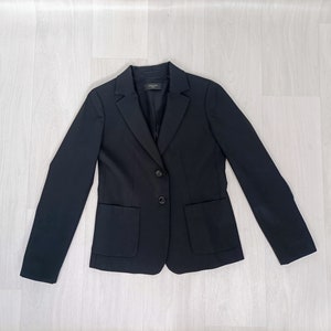 Può includere: Un blazer nero con due bottoni e due tasche.