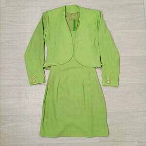 May include: A lime green dress suit with a short jacket and a knee-length skirt.