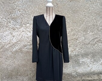 Könnte beinhalten: Ein schwarzes Kleid mit einem Samtpanel an der Seite. Das Kleid hat lange Ärmel und einen V-Ausschnitt.