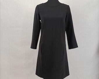 May include: A black, long-sleeved dress with a simple, round neckline and a slightly A-line silhouette.