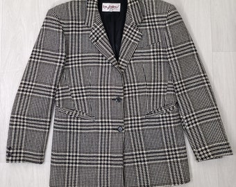 May include: A black and white plaid blazer with a notched collar, two front pockets, and a two-button closure. The blazer has a black lining and the label "byblos" is visible. The pattern is a classic houndstooth design.