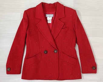 May include: A red blazer with a speckled pattern and double breasted closure. The blazer has two flap pockets and brown buttons.