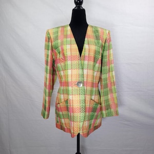 May include: A colorful plaid blazer in shades of green, pink, and orange. The blazer has a V-neck, long sleeves, and two front pockets. It is fastened with a silver-colored button. The garment is displayed on a black mannequin.