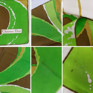 Op de afbeelding: Een groene, bruine en witte zijden sjaal met een abstract ontwerp. De sjaal heeft de tekst "Christian Dior" erop gedrukt.