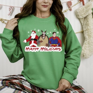 May include: Green Christmas sweater with a Santa Claus, armadillo, and Superman graphic. The text "HAPPY HOLIDAYS" is printed below the graphic.