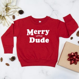 May include: Red long-sleeved sweatshirt with white text that reads "Merry Little Dude".
