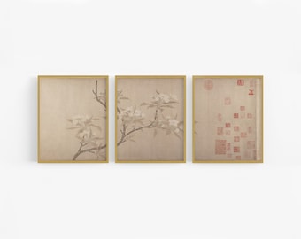 Op de afbeelding: Drie ingelijste prints met een minimalistische esthetiek. De linker en middelste prints tonen een delicate tak met witte bloesems op een beige achtergrond. De rechter print toont een patroon van rode vierkanten en cirkels op een beige achtergrond.