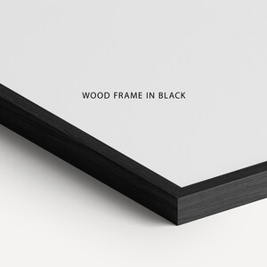 May include: Close-up of a black wood frame. The frame is made of a dark wood and has a smooth finish. The text "WOOD FRAME IN BLACK" is printed on the white surface inside the frame.