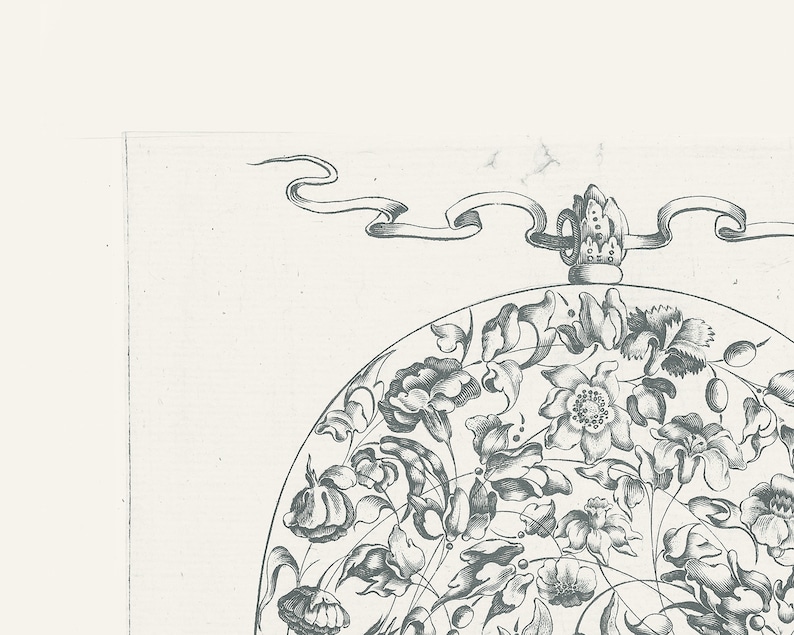 May include: A black and white illustration of a circular design with a floral motif. The design features a crown at the top and a ribbon flowing from the crown.