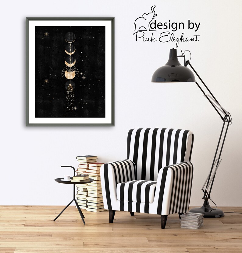 Puede incluir: Una impresi&oacute;n enmarcada con fondo negro y fases lunares doradas. La impresi&oacute;n est&aacute; colgada en una pared blanca sobre un sill&oacute;n de rayas blancas y negras. El texto "design by Pink Elephant" es visible en la esquina superior derecha de la imagen.