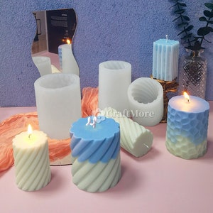 Può includere: Assortimento di stampi per candele in varie forme e dimensioni, tra cui uno stampo cilindrico, uno stampo a spirale e uno stampo a nido d'ape. Gli stampi sono in silicone bianco e sono mostrati con le candele all'interno.