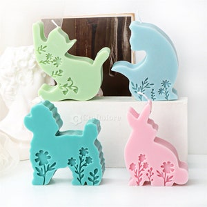 May include: Four decorative candles shaped like a cat, dog, rabbit, and another cat. The candles are all different colors and have a floral design.