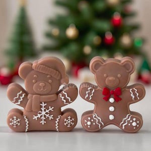 Può includere: Due decorazioni a forma di orsetto di pan di zenzero marrone. Un orso indossa un cappello e una sciarpa con dettagli a fiocco di neve. L'altro orso ha un papillon rosso e dettagli di glassa bianca. Un albero di Natale è sullo sfondo.