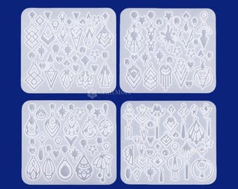 May include: Four clear silicone molds with various earring designs. Each mold is a square shape and contains multiple earring shapes, including teardrops, stars, and geometric patterns. The molds are on a dark blue background.
