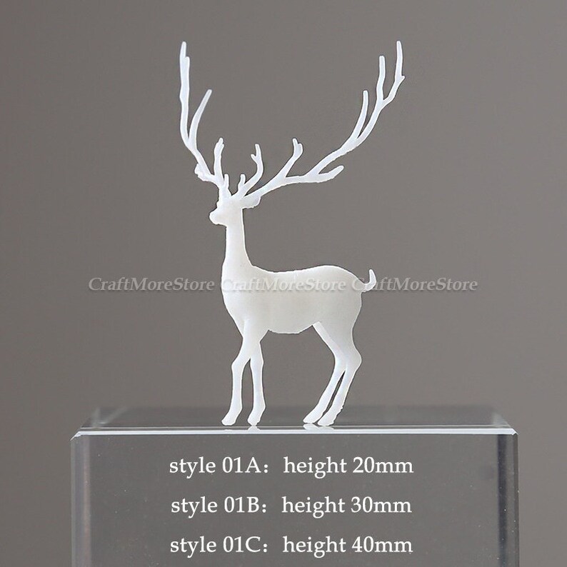 Pu&ograve; includere: Silhouette di cervo in plastica bianca con grandi corna. Il cervo &egrave; in piedi su un blocco di vetro trasparente con il testo "style 01A: altezza 20 mm", "style 01B: altezza 30 mm" e "style 01C: altezza 40 mm".