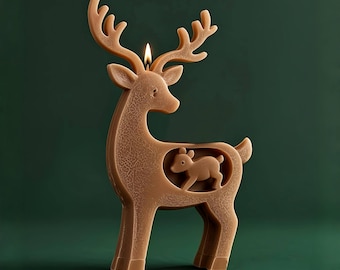 May include: A brown reindeer-shaped candle with a smaller reindeer cutout inside. The candle has detailed antlers and a lit wick. The background is a dark green, creating a festive holiday theme.