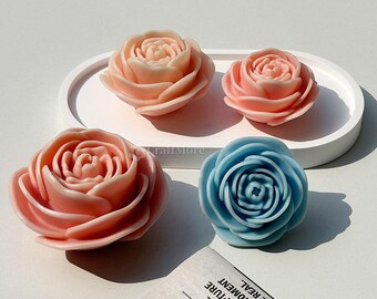 May include: Four handmade soap roses, two in pink and two in blue, are displayed on a white oval tray. The roses are detailed and realistic, with multiple layers of petals.