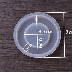 May include: A clear silicone mold for resin crafts. The mold is 7 inches in diameter and has a circular indentation in the center that is 3.7 inches in diameter. The indentation is 1.1 inches wide and 6 centimeters deep.