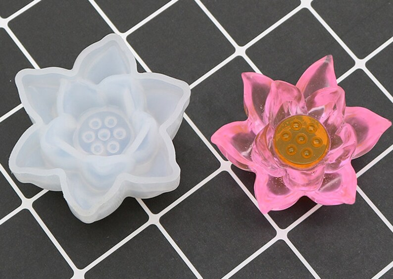 May include: A white silicone mold and a pink resin lotus flower. The mold and flower have a detailed design with eight petals and a center with eight holes.