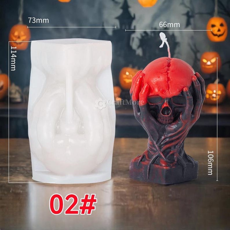 Op de afbeelding: Een witte siliconen mal voor het maken van een schedelkaars. De mal is 7,3 cm breed en 11,4 cm hoog. De afgewerkte kaars is een rode en zwarte schedel met handen die de schedel vasthouden. De kaars is 6,6 cm breed en 10,6 cm hoog. De mal is gemarkeerd met "02#"