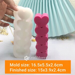 May include: A white silicone mold for making stacked heart-shaped soap or candles. The mold is 16.5x5.5x2.6 cm and the finished product is 15x3.9x2.4 cm.