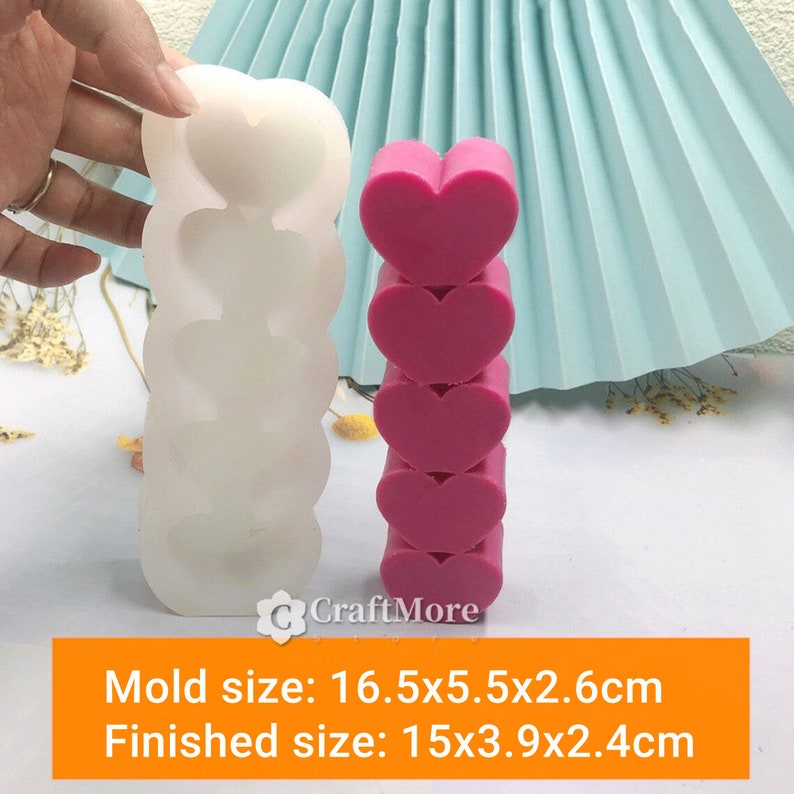 May include: A white silicone mold for making stacked heart-shaped soap or candles. The mold is 16.5x5.5x2.6 cm and the finished product is 15x3.9x2.4 cm.