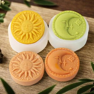 May include: Four silicone molds for making soap or candles. The molds are round and feature a sun and moon design. The sun and moon are yellow, green, and orange.