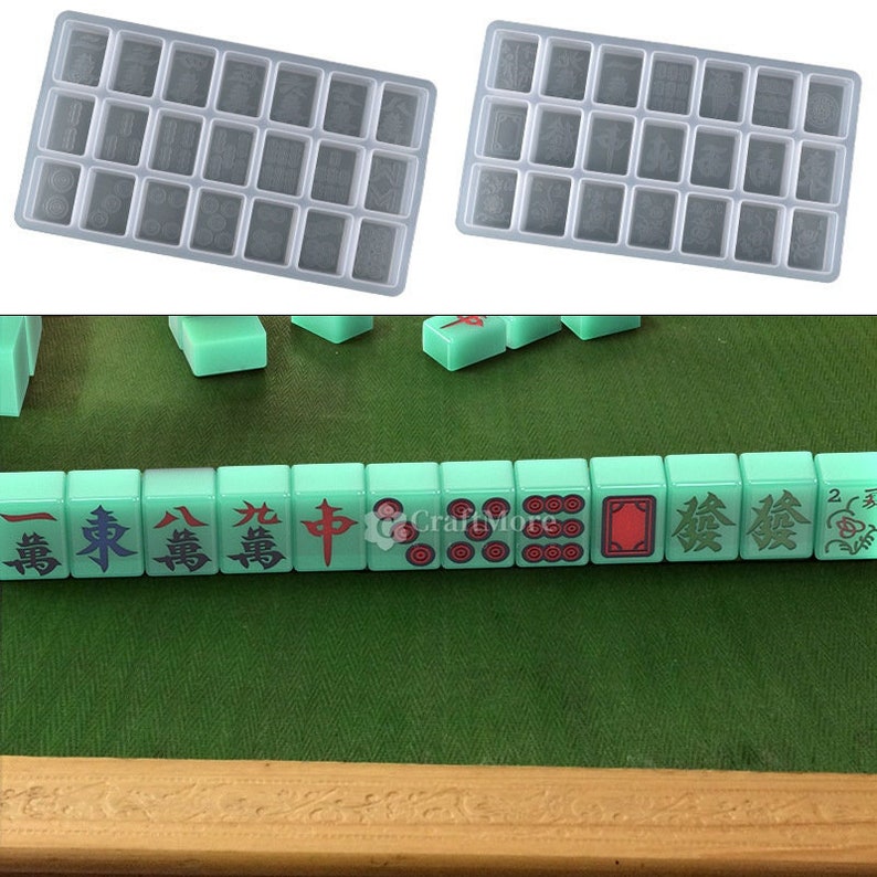 May include: A set of two clear plastic trays with 24 individual compartments, designed for making mahjong tiles. The trays are shown next to a row of green mahjong tiles with Chinese characters and symbols.