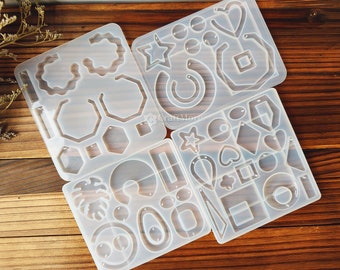 May include: Four clear silicone molds for making earrings. The molds feature various shapes, including circles, ovals, hearts, stars, and geometric shapes.