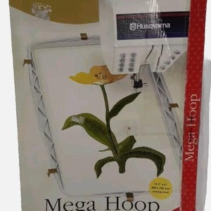 May include: A Husqvarna Mega Hoop box features a detailed embroidered flower design. The box is red and white, with the Husqvarna and Viking logos. The hoop size is 14.3" x 6" (360 x 150 mm).