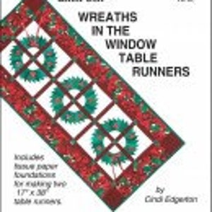 May include: A book cover for a quilting pattern featuring a red, green, and white table runner with three wreaths. The title is "Wreaths in the Window Table Runners" by Cindy Epperly. The book includes foundation paper piecing instructions for making 17 x 30 inch table runners.