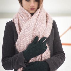 May include: A woman wearing a gray coat and a pink scarf with dark green gloves.