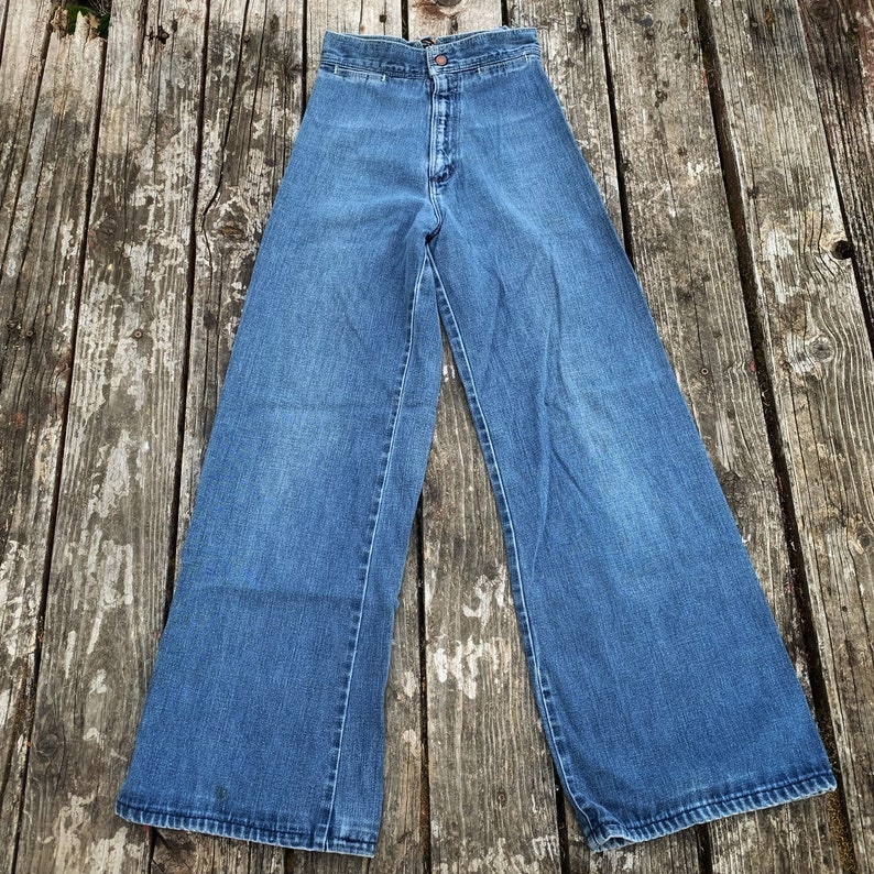 May include: A pair of blue denim wide-leg trousers with a high waist and a straight leg.