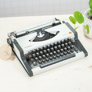Máquina de escribir Olympia Traveler, década de 1970, con mantenimiento profesional y en funcionamiento. ENVÍO RÁPIDO EN 1-3 DÍAS. Cinta de tinta nueva, qwertz.