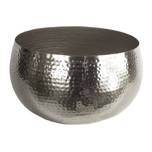 May include: A large, silver, hammered metal bowl. The bowl is round and has a smooth, shiny surface.