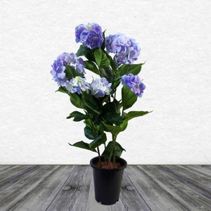 May include: A potted artificial hydrangea plant with multiple blue and purple flower clusters. The plant has green leaves and is in a black plastic pot.