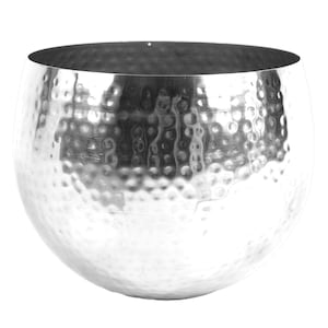 May include: A silver hammered metal planter with a round shape. The planter is made of a shiny metal with a textured surface.