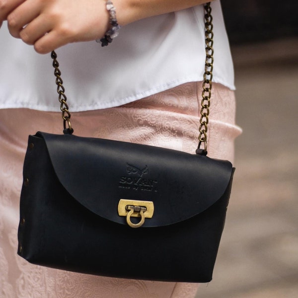 Glossy black leather clutch with braided passementerie