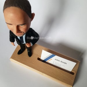 Lawyer bobblehead from above with business card in card holder.