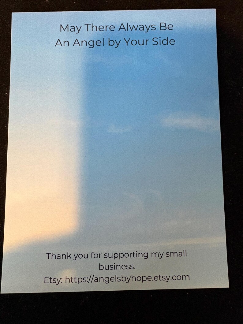 Puede incluir: Una tarjeta rectangular con un fondo tem&aacute;tico de cielo, con el texto "May There Always Be An Angel by Your Side." La parte inferior de la tarjeta dice "Thank you for supporting my small business." y la URL de la tienda Etsy.