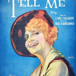 May include: A vintage sheet music cover featuring a woman with blonde hair wearing a red hat and a yellow shirt. The title of the song is "Tell Me" and the lyrics are by J. Will Callahan and the music is by Max D. Kortlander. The cover is posed by Miss Ruby de Remer, a film star.